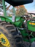 Magnetic koozie holding a bottle on a green tractor for hands-free beverage convenience outdoors